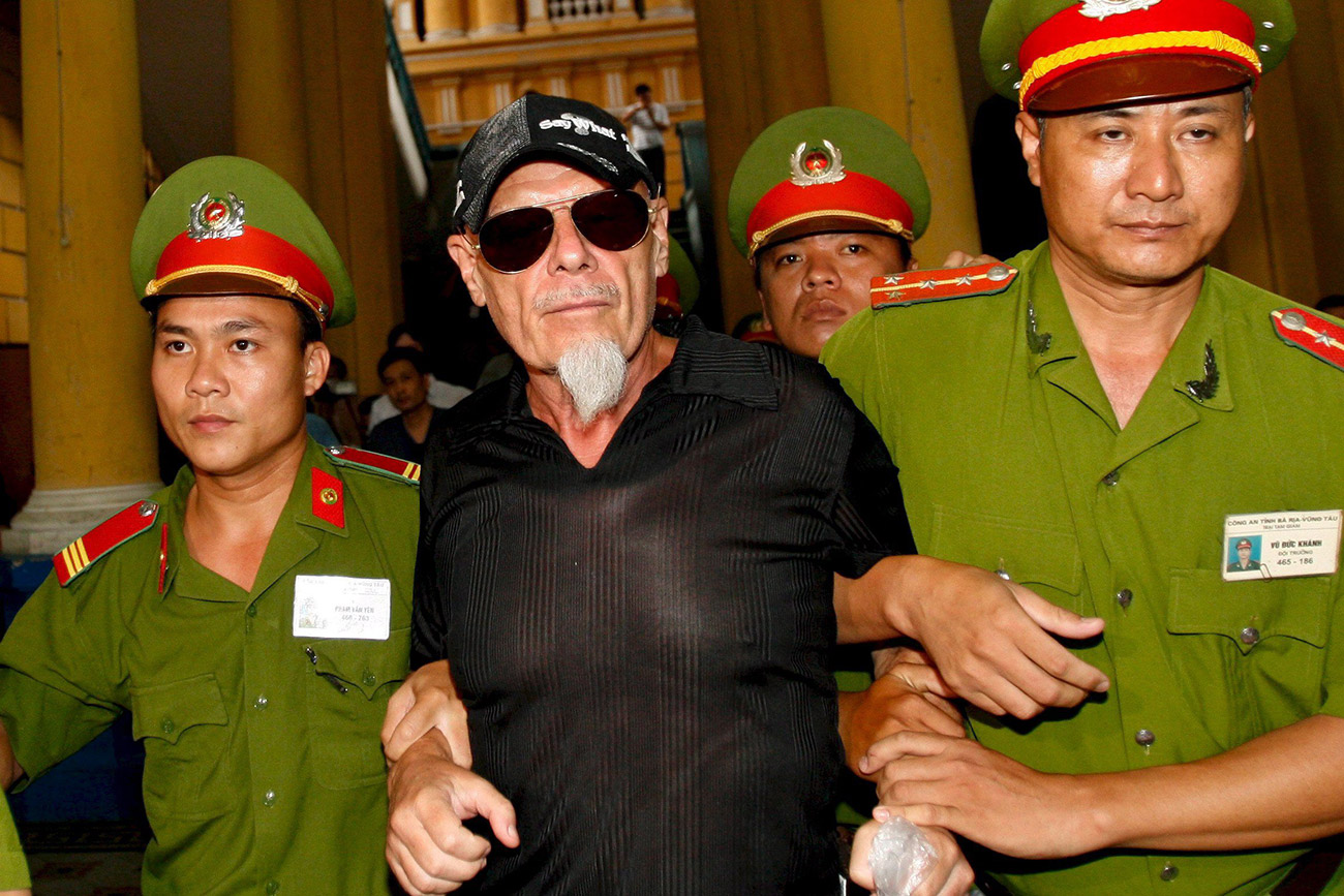 file picture dated 15 June 2006 shows British glam rock star Gary Glitter (C) escorted by police into a courtroom for his appeal hearing in a child molestation case in Ho Chi Minh City, Vietnam. Glitter, whose real name is Paul Gadd,