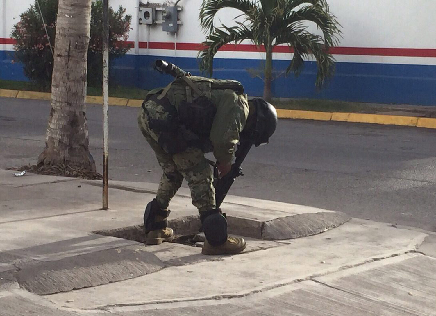 A member of Mexican Navy Force points with his weapon into a sewer during military operations after recapturing Mexican drug lord Joaquin "El Chapo" Guzman