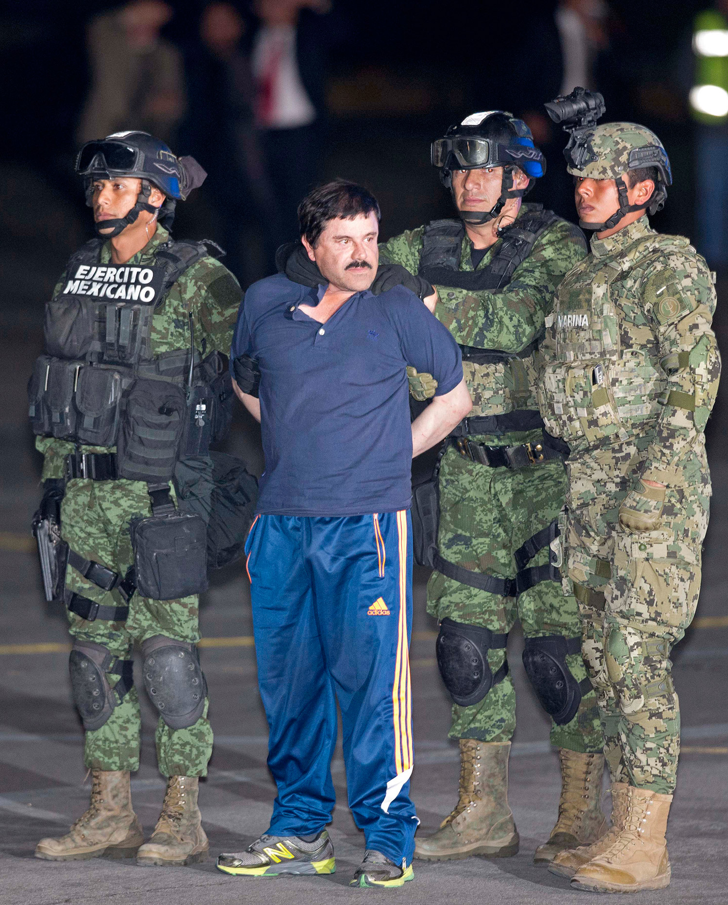 Recaptured drug lord Joaquin "El Chapo" Guzman is escorted by soldiers during a presentation in Mexico City, January 8, 2016