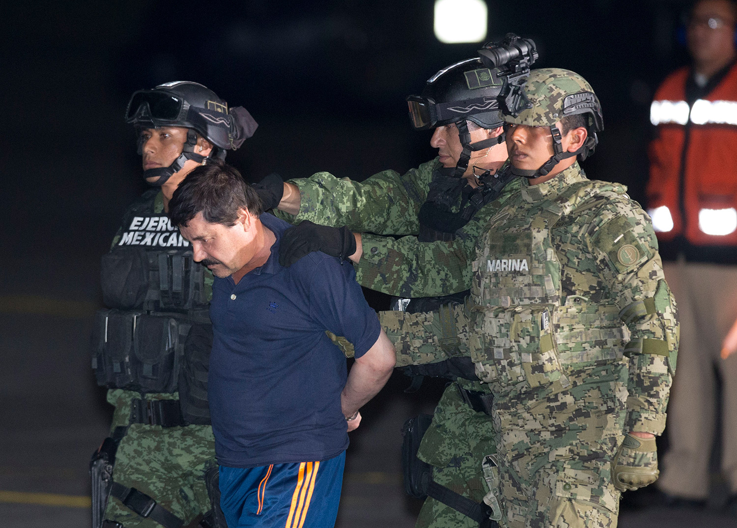 oaquin "El Chapo" Guzman is escorted to a helicopter in handcuffs by Mexican soldiers and marines at a federal hangar in Mexico City, Mexico, Friday, Jan. 8, 2016.