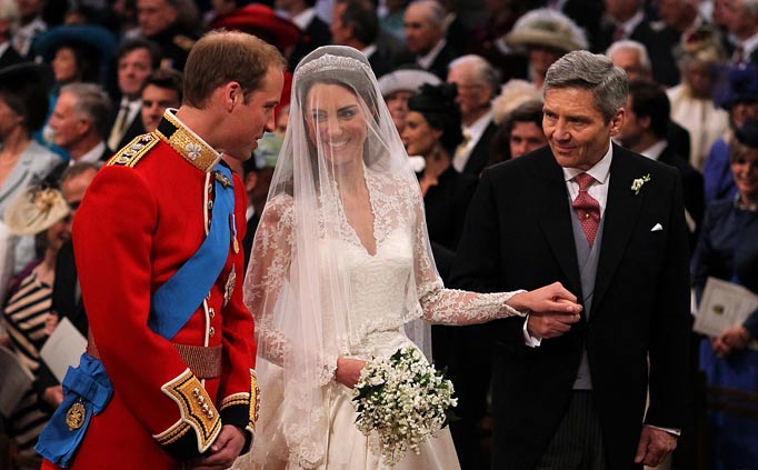 Britain's Prince William (L) looks at his bride Kate Middleton (C), as she holds her father Michael Middleton's hand during the Royal wedding ceremony at Westminster Abbey in London on April 29, 2011.