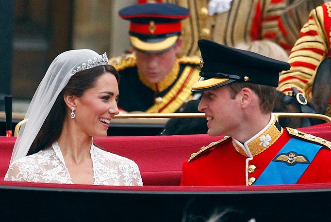 Britain's Prince William, and Catherine, Duchess of Cambridge smile as they travel to Buckingham Palace in the 1902 State Landau, along the Procession Route, after their wedding in Westminster Abbey.