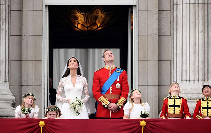 Britain's Prince William and his wife Kate, Duchess of Cambridge look up as the Royal Air Force perform a flypast while they stand on the balcony of Buckingham Palace in London, after their wedding ceremony, on April 29, 2011.