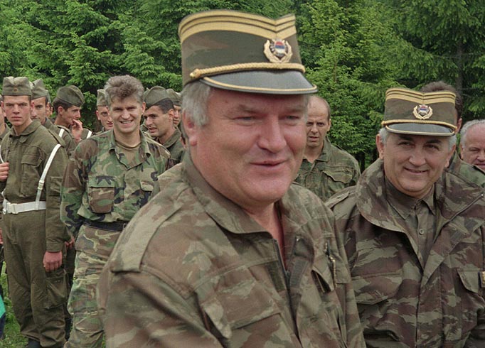 In this June 28, 1996 file photo Bosnian Serb military commander General Ratko Mladic, center, smiles as he visits troops to mark both the fourth anniversary of the founding of his Bosnian Serb army and St. Vitus' Day, the anniversary of the Serb defeat by the Turks at Kosovo in 1389, near the village of Han Pijesak, some 40 miles east of Sarajevo.