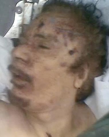 Grab from one of the latest video recordings posted on Youtube showing images of the former Libyan leader Muammar Gaddafi with a bullet hole on the left side of his head lying dead shortly after being shot following his capture in his home town of Sirte