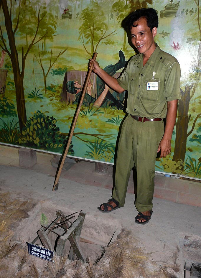 A guide demonstrates one of the cunning and lethal booby traps used to defend the Cu Chi tunnel