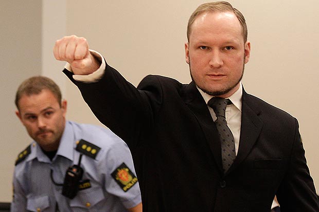 Mass murderer Anders Behring Breivik, makes a salute after arrives at the court room in a courthouse in Oslo Friday Aug. 24, 2012