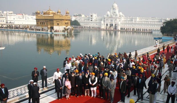 British Prime Minister David Cameron, front center wearing tie, visits the Golden Temple, Sikh's holiest shrine, along with Chief Minister of Punjab state Parkash Singh Badal, second from left wearing glasses, in Amritsar, India, Wednesday, Feb. 20, 2013.