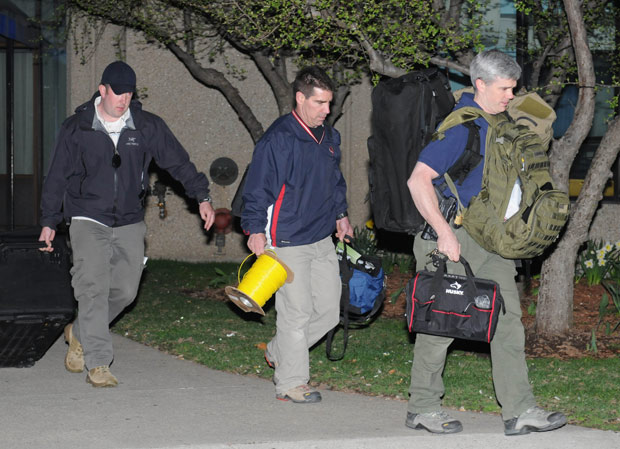 Police and federal officials exit an apartment complex at 364 Ocean Avenue with a possible connection to the earlier expolsions during the Boston Marathon on April 15, 2013 in Revere, Massachusetts.