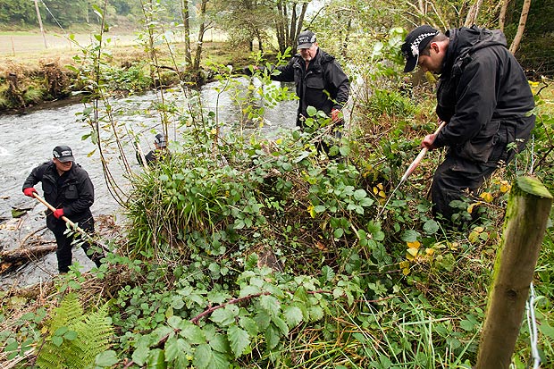 Police search teams search the Dyfi river banks near Mark Bridgers home in Ceinws village near Machynlleth.