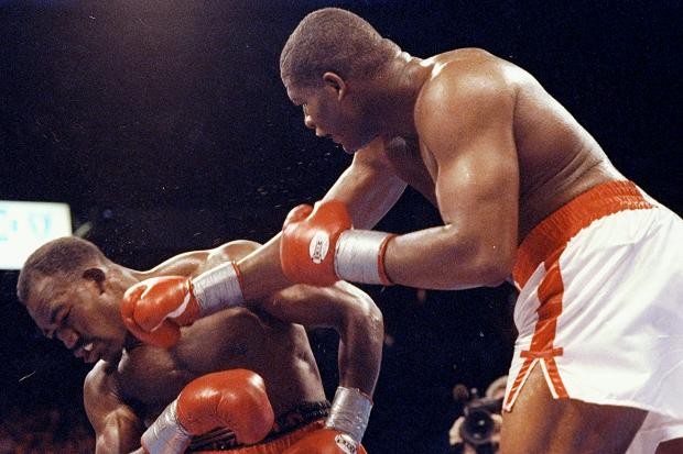 Riddick Bowe lands a right on Evander Holyfield's jaw