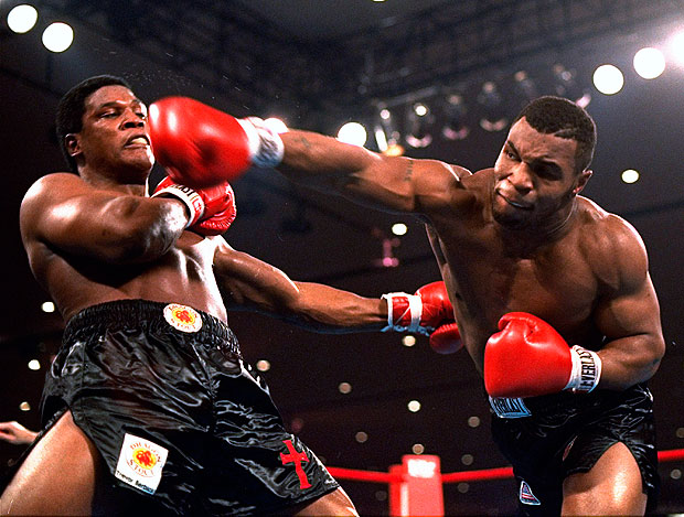 Mike Tyson, right, delivers a powerful blow to Trevor Berbick