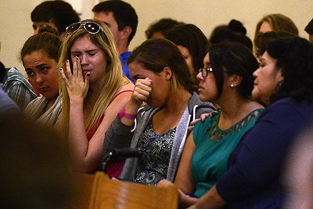 Church attendees cry during a prayer service for victims of the shooting rampage