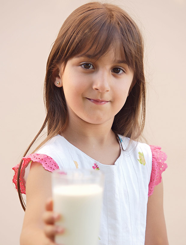 adorable girl drinking milk focus in the face