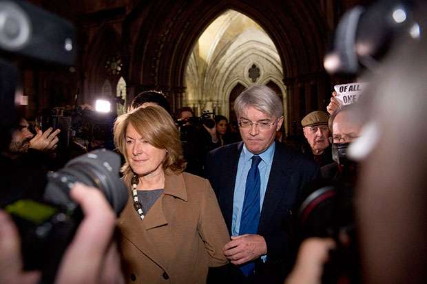 Andrew Mitchell, right, Britain's former government chief whip, and his wife Sharon walk away after the ruling was given in his case at the High Court in London, Thursday, Nov. 27, 2014