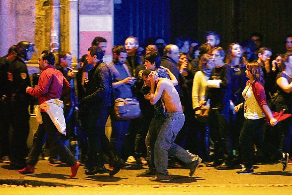 Injured music fans are led from Bataclan