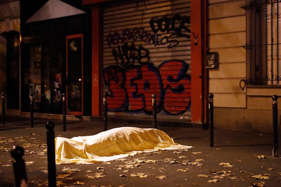 A victim under a blanket lays dead outside the Bataclan theater in Paris, Friday Nov. 13, 2015. Well over 100 people were killed in a series of shooting and explosions. French President Francois Hollande declared a state of emergency and announced that he was closing the country's borders.