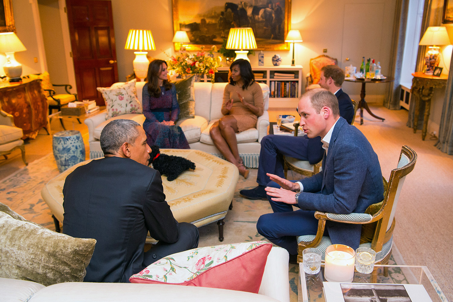 Britain's Prince William, right, talks with U.S. President Barack Obama, with Kate Duchess of Cambridge, back left, Michelle Obama, back right, and Prince Harry, obscured right, in the Drawing Room of Kensington Palace in London, prior to a private dinner hosted by Prince William and Kate, Friday April 22, 2016. President Barack Obama and first lady Michelle plunged into a whirlwind visit to England with royal socializing and political talks.