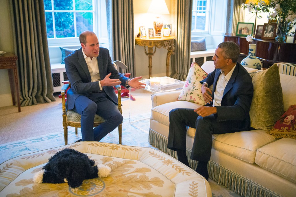 The Duke of Cambridge talks to Barack Obama next to the stuffed black and white toy dog given to George by the Obamas