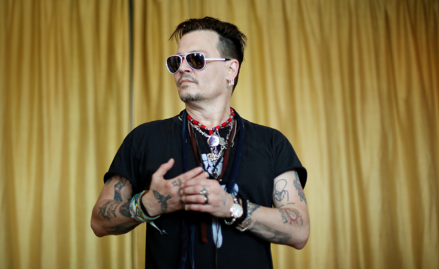 Joe Perry (L), Alice Cooper (R) and Johnny Depp of the band Hollywood Vampires put hearing devices to a patient during a charitable event with Starkey Hearing Foundation in Lisbon, Portugal May 27, 2016. REUTERS/Rafael Marchante TPX IMAGES OF THE DAY