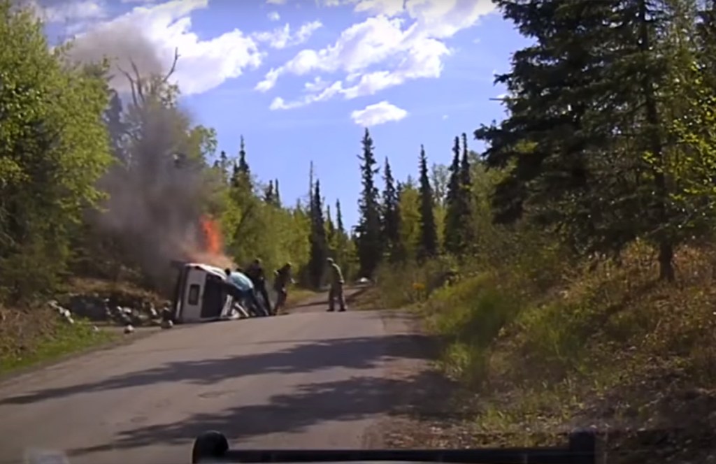  The man manages to slip out of the car after another passer-by helps to push