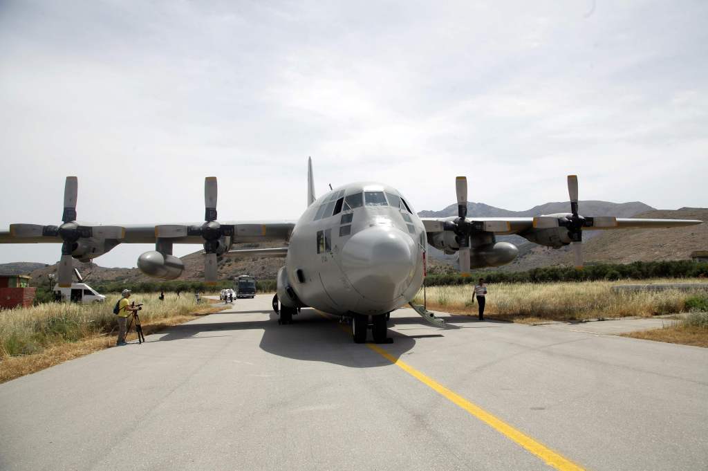 A cameraman films a C-130 plane of the