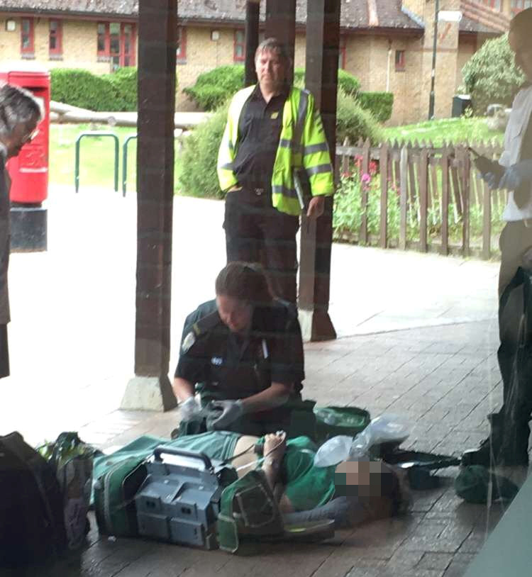  A woman lies bloodied outside the police station near a Sainsbury's store where three women were stabbed after one victim staggered to tell cops of the attack