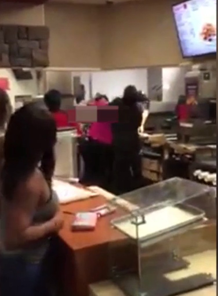 The brawl broke out behind the McDonald's counter as customers ordered at the till