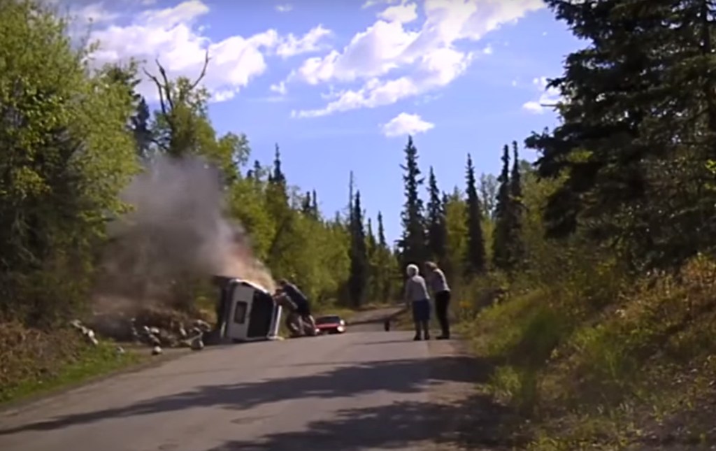  The trio push against the car but only shift the vehicle a bit