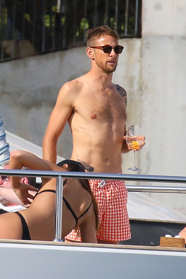  Jenson Button holds his glass while Brittny Ward spends time adjusting her bikini