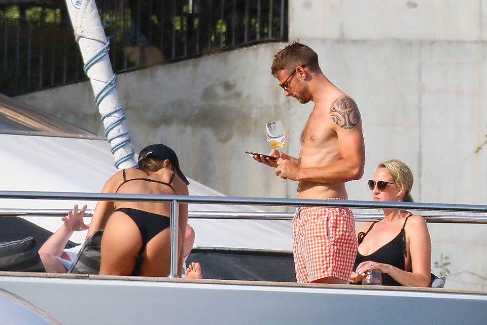  Jenson Button is too distracted by his phone to notice Brittny Ward’s pose