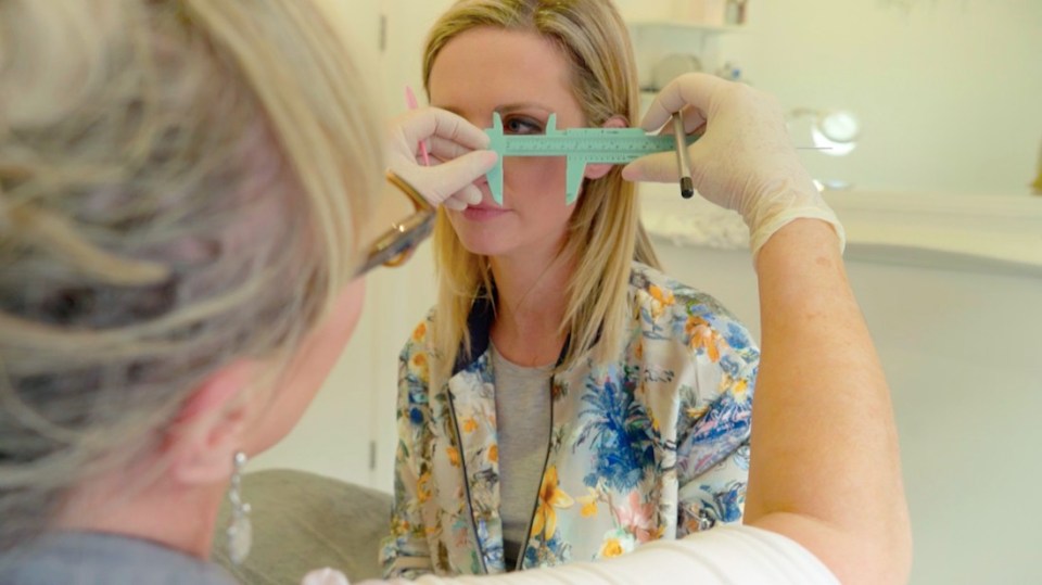 Tracie, the eyebrow expert, carefully draws on the eyebrows before using a needle