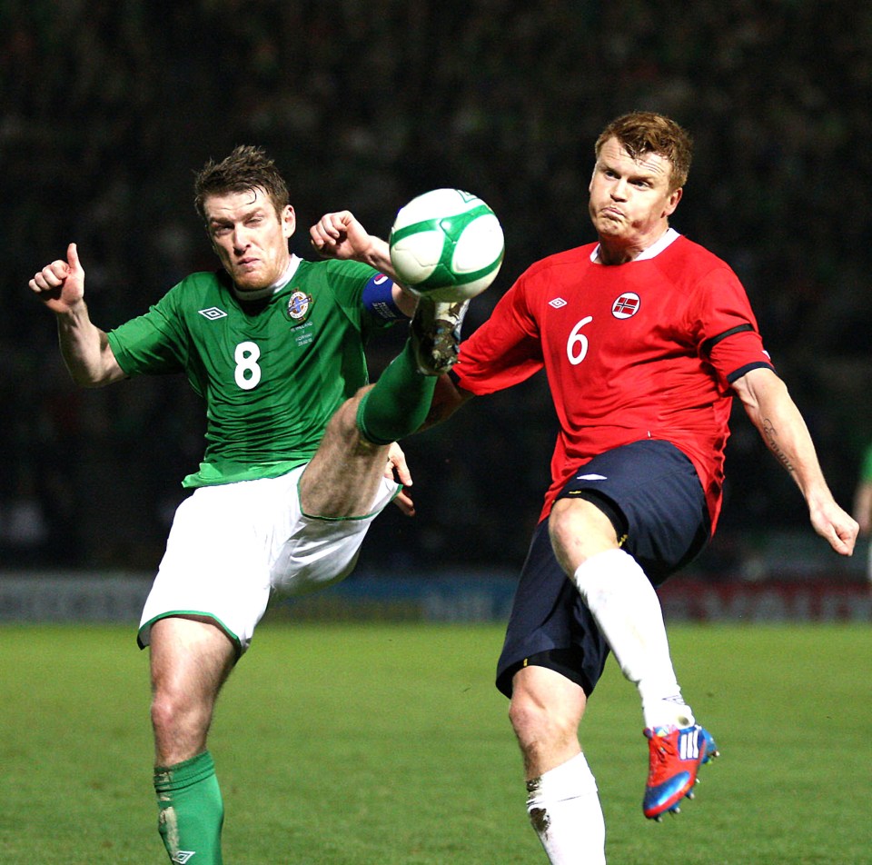 Riise up against Northern ireland midfielder Steven Davis in one of his 110 caps 