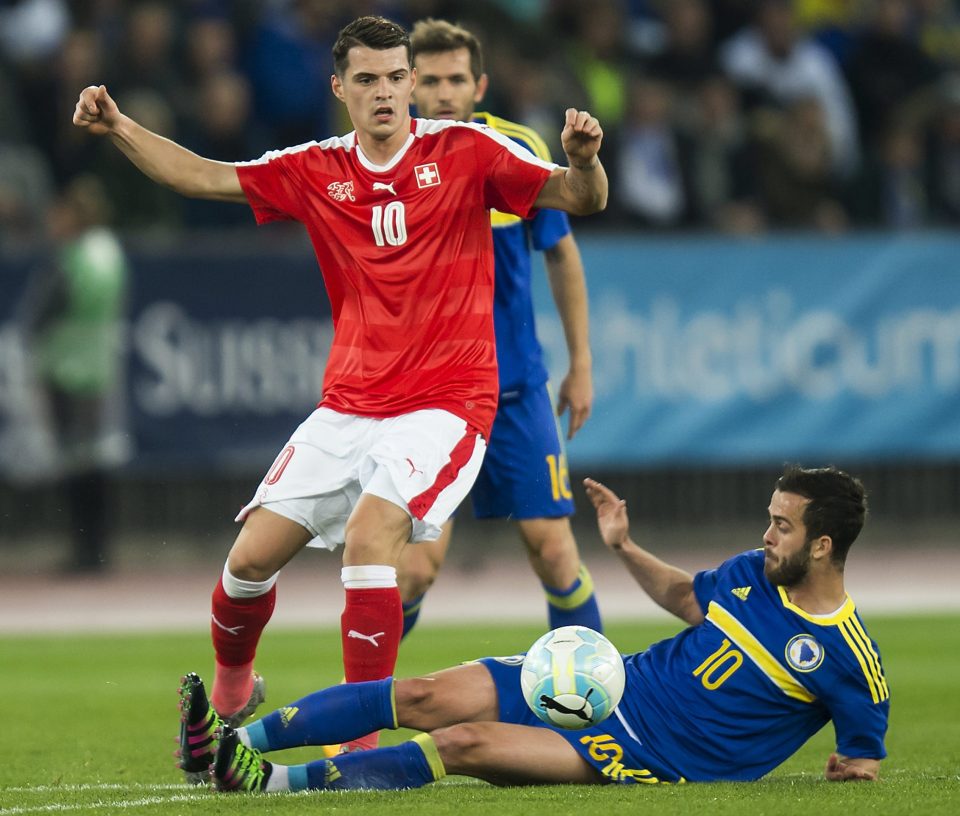 Swiss midfielder Granit Xhaka evades Bosnia star Miralem Pjanic in a friendly at Zurich