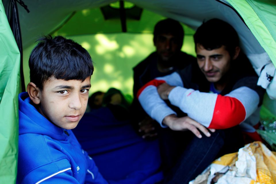 Refugees from Afghanistan sit in a tent before they are made to move on