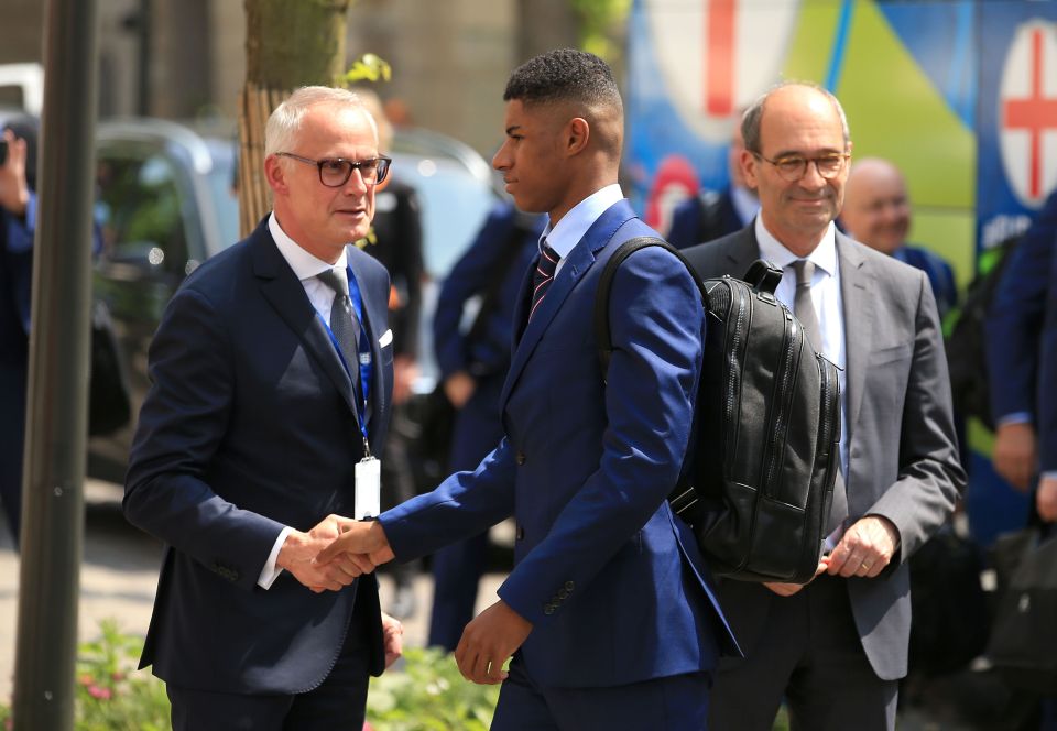  England's young striker Marcus Rashford is greeted by the squad's hotel manager