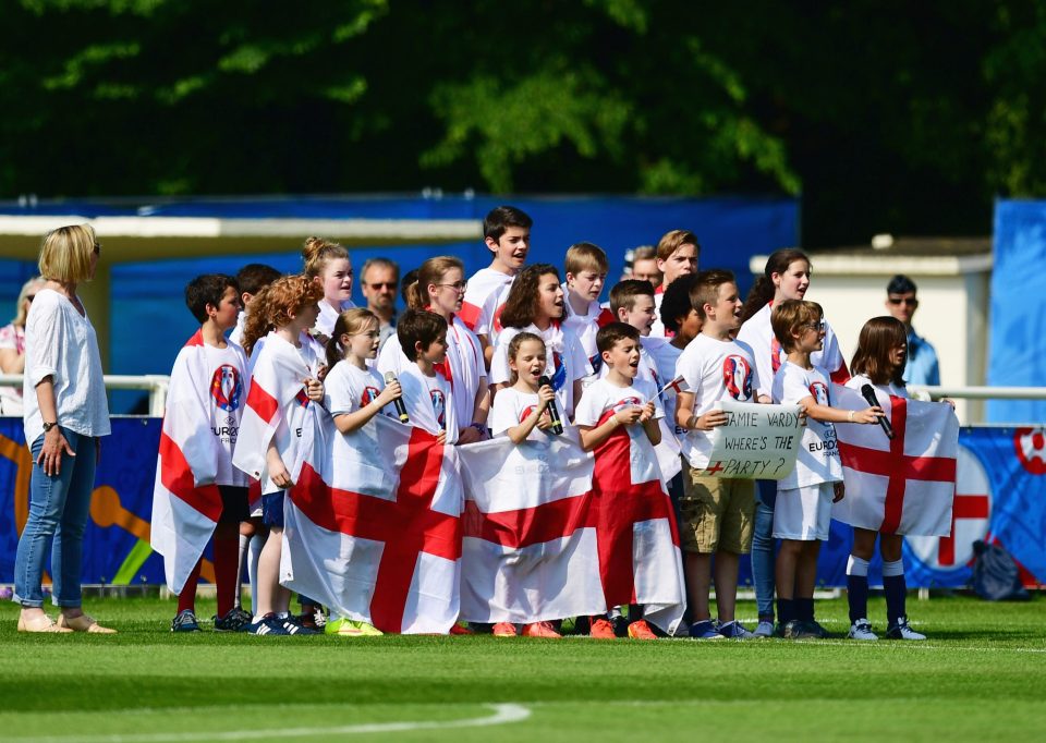 Children sing the national anthem as players are welcomed during an England training session 