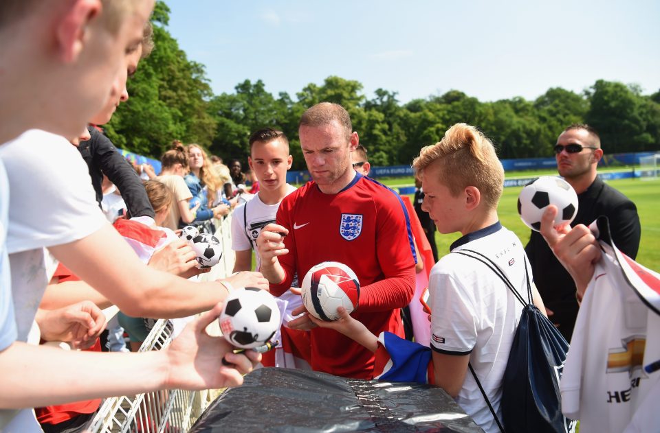 Captain Wayne Rooney signs autographs after an England training session