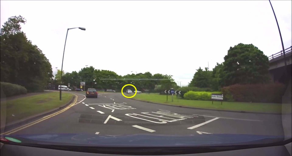 CAR REVERSES AROUND ROUNDABOUT