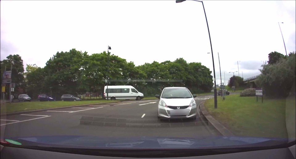 CAR REVERSES AROUND ROUNDABOUT