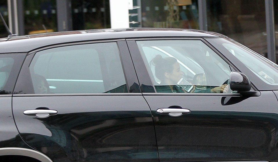  Rachel is spotted with one hand on the wheel and one hand holding her phone as she drives down the road