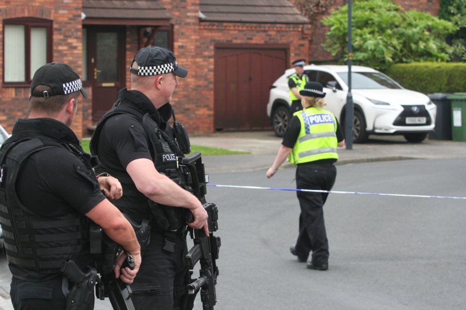  Armed cops were stood outside a property where the middle-aged woman was knifed at roughly 11am