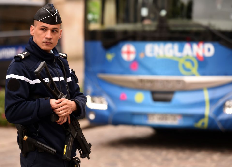  An armed police officer stands by England team's bus as the players leave their hotel in Chantilly, north France, on June 9