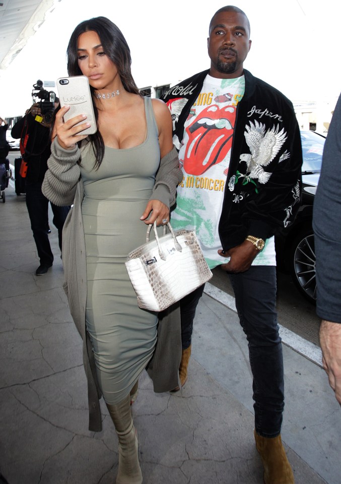 Kim was caught up in her phone as they headed to the terminal, with Kanye having to guide his wife along 