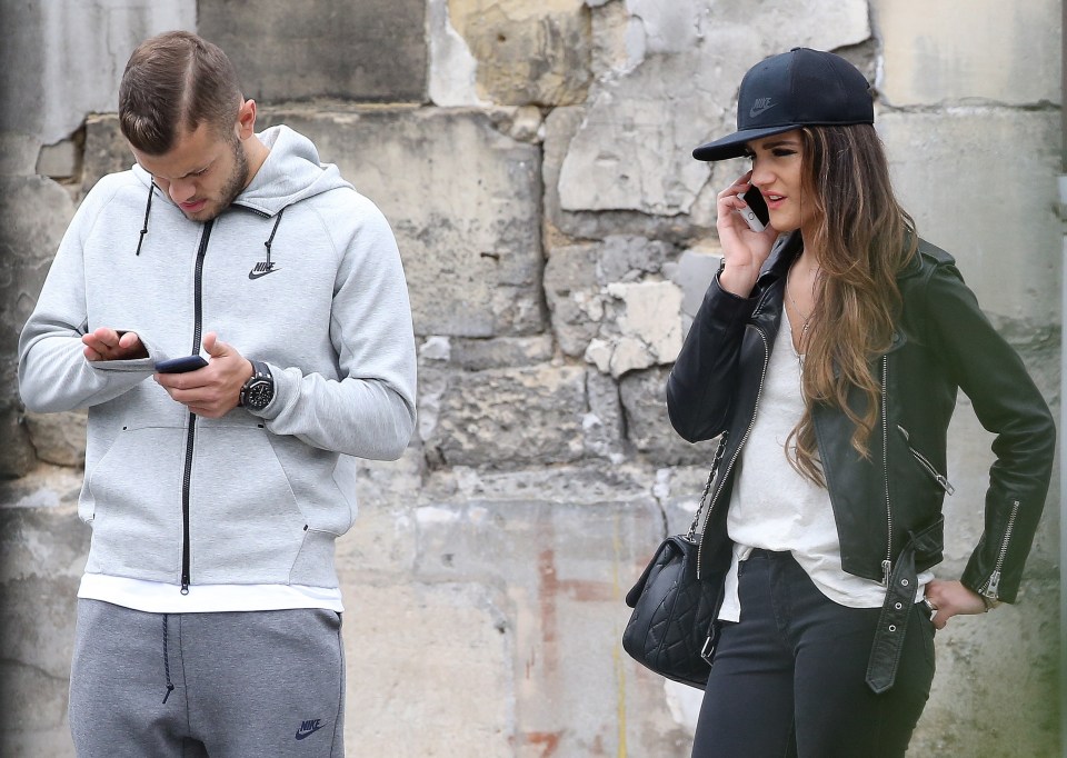  Jack Wilshere and Andriani Michael play on their phones in Chantilly