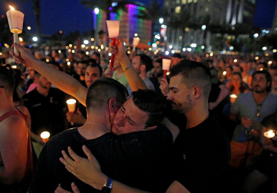  People gather for a candlelight vigil during a memorial service for the victims of the shooting at the Pulse gay night club in Orlando