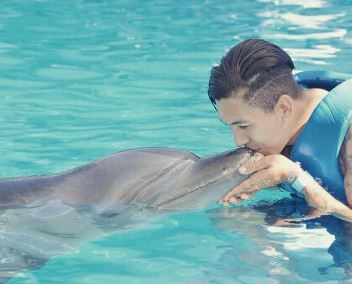 Roberto Firmino kisses the dolphin as he relaxes in Cancun, Mexico