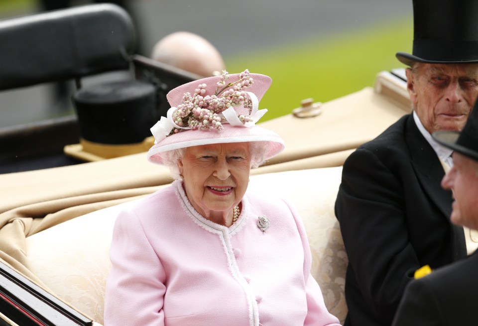  The Queen wears ornamental berries around the brim of her pale pink hat for the second day of racing at the famed festival