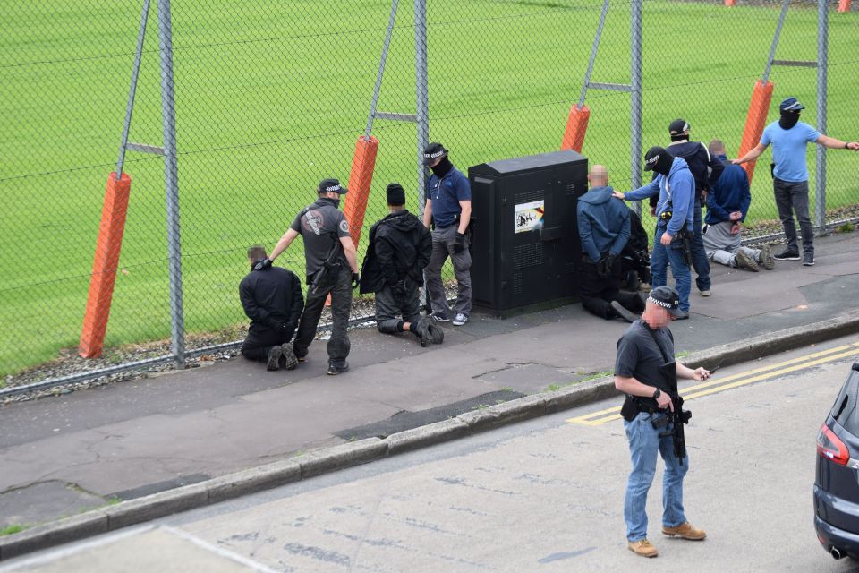 Five men alleged to have committed robbery were bundled into the back of a police van by armed officers following the swoop