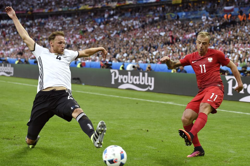  German defender Benedikt Hoewedes tries to stop Kamil Grosicki getting a cross in